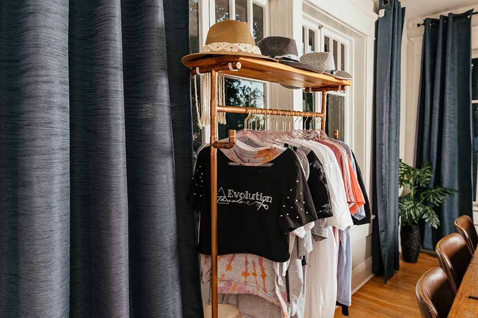 Evolution Threads clothes and hats on a rack.