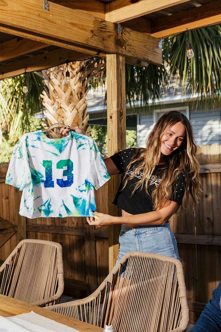 Woman holding up a custom craft made tshirt on game day