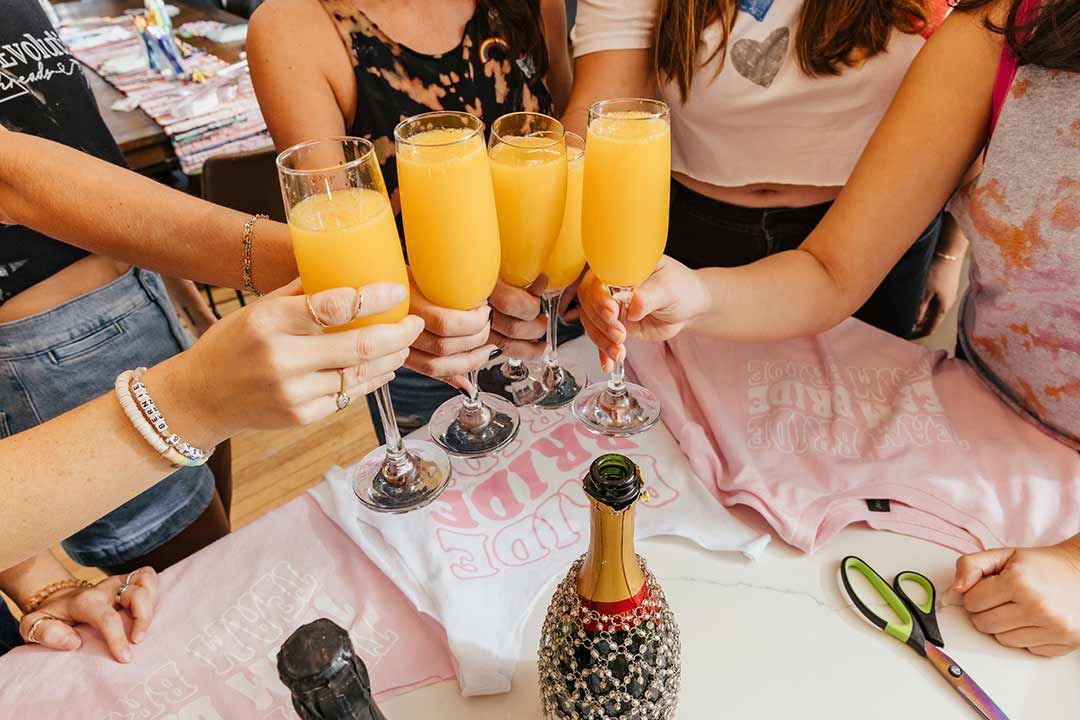 Friends toasting with drinks at a bachelorette party