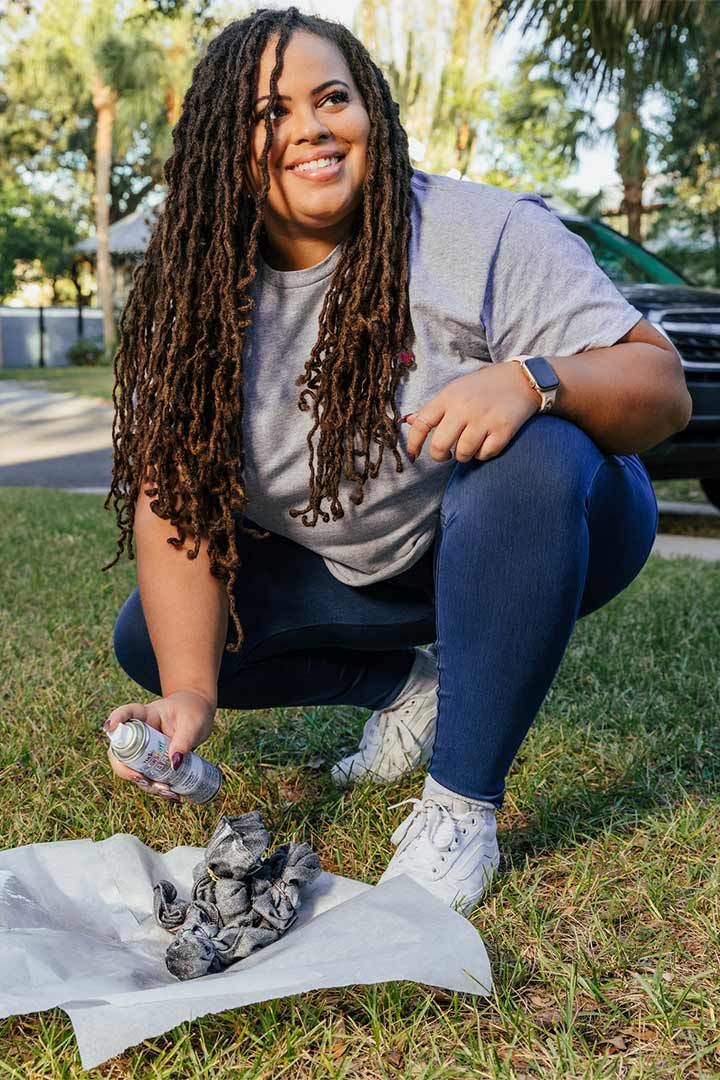 Woman spray painting a craft tshirt outside